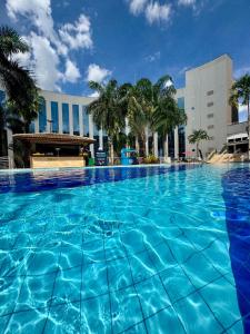 a large pool with blue water in front of a building at Apartamento Barretos Park Hotel in Barretos
