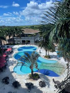 an overhead view of a pool with chairs and palm trees at Apartamento Barretos Park Hotel in Barretos