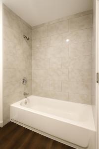 a white bath tub in a bathroom with tiles at Angelic in Tacoma