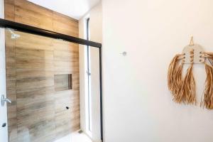 a shower with a glass door in a bathroom at La Veleta Hotel - Pool Access Room in Tulum