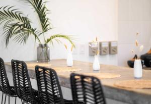 a table with black chairs and white vases on it at La Veleta Hotel - Pool Access Room in Tulum