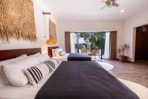 a bedroom with two beds and a living room at La Veleta Hotel - Tulum Vibes - Pool View in Tulum
