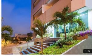 巴兰基亚Atlantis Suites -Amoblados Nuevos sector Buenavista的前面有楼梯和棕榈树的建筑