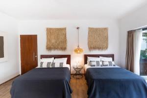een slaapkamer met 2 bedden met blauwe lakens bij La Veleta Hotel - Trendy Stay - Pool View in Tulum