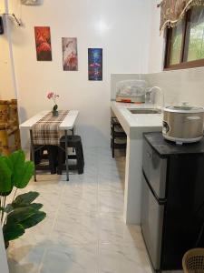 a kitchen with a sink and a table with a pot at Panglao Transient house close to nature with bonfire in Panglao
