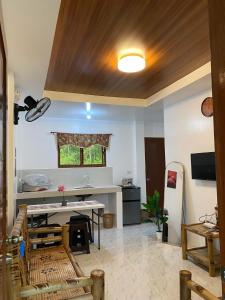a living room with a table and a kitchen at Panglao Transient house close to nature with bonfire in Panglao