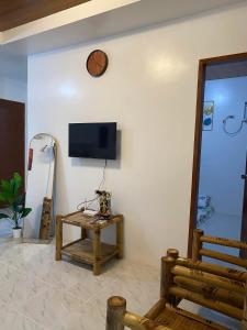 a living room with a table and a tv on a wall at Panglao Transient house close to nature with bonfire in Panglao