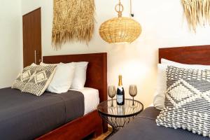 a bedroom with two beds and a table with wine glasses at La Veleta Hotel - Relax & Recharge - Pool View in Tulum