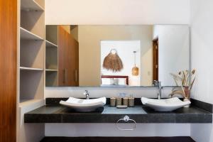a bathroom with two sinks and a mirror at La Veleta Hotel - Relax & Recharge - Pool View in Tulum