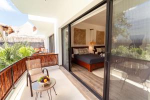 a room with a balcony with a bed and a table at La Veleta Hotel - Relax & Recharge - Pool View in Tulum