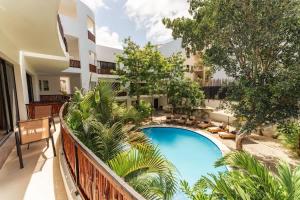 an apartment balcony with a swimming pool and trees at La Veleta Hotel - Relax & Recharge - Pool View in Tulum +31 photos