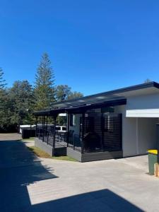 a building with a screened in porch on the side of it at Coastal Charm in Port Macquarie