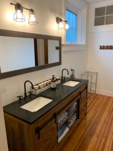 a bathroom with two sinks and a large mirror at Riverbend Berkshire East Basecamp in Charlemont