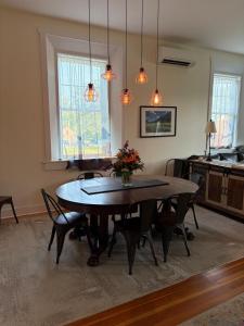 a dining room with a table and chairs and lights at Riverbend Berkshire East Basecamp in Charlemont