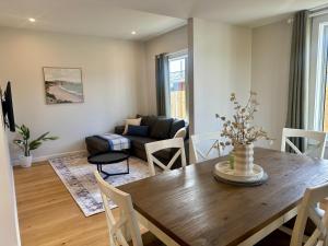 un soggiorno con un tavolo di legno e un divano di Kilda Cottage - Close to beach a Dunedin