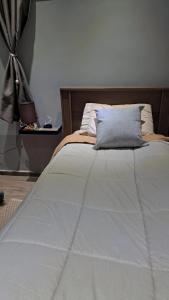 a bed with a blue pillow on top of it at Pousada Vida & Brisa in Pelotas