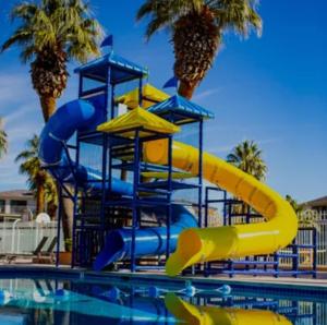 a water slide in a pool with palm trees at Spacious 5BR Resort Waterpark Access Sleeps 16 in Saint George Municipal Airport
