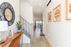 a hallway with white walls and a staircase with a mirror at Spacious 5BR Resort Waterpark Access Sleeps 16 in St. George +39 photos