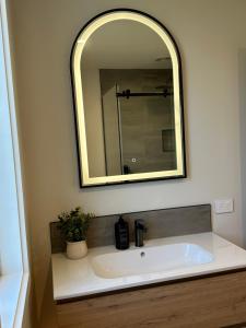 un bagno con lavandino e specchio di Kilda Cottage - Close to beach a Dunedin Altre 10 foto
