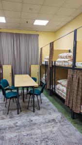 a room with two bunk beds and a table and chairs at Sun Hostel in Almaty +29 photos