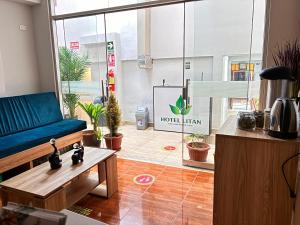 a living room with a couch and potted plants at Hotel Litan Machu Picchu in Machu Picchu