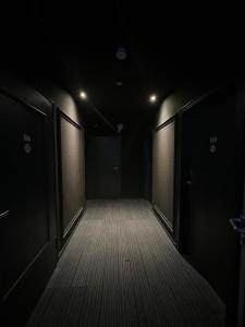 an empty corridor with two doors in a dark room at Hotel Monopol City Centre in Düsseldorf