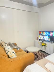 a living room with a couch and a tv at Rosarium house in Nanyuki