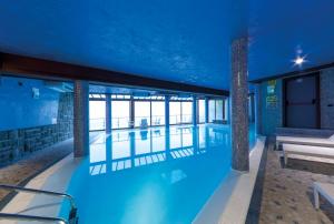a swimming pool in a building with a blue ceiling at Hotel Cristallo Cerreto Laghi in Cerreto Laghi