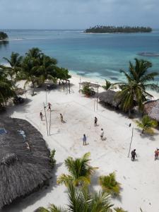 people on a beach with palm trees and the ocean at San Blas Cayos Holandeses, Anaimar  +8 photos