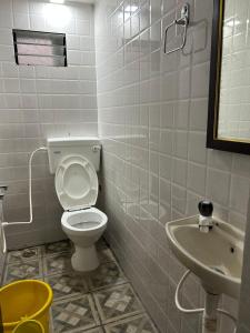 ein Badezimmer mit Toilette und Waschbecken in der Unterkunft Hotel Guest Inn in Mysore