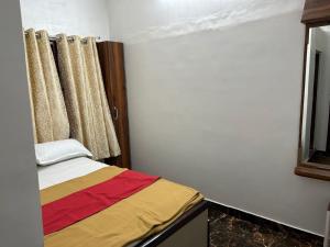a small room with a bed and a window at Hotel Guest Inn in Mysore