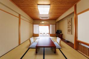 a room with a table and chairs and a window at Yorozuya in Yamanouchi