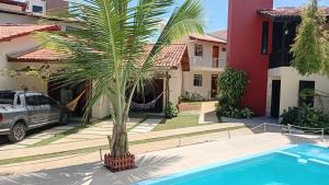 a palm tree in front of a house at Solaris do Atlantico in Ilhéus