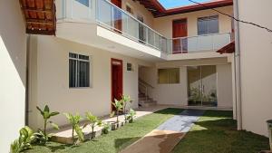 a home with a red door and a balcony at Solaris do Atlantico in Ilhéus