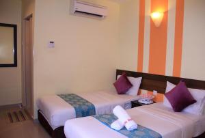 a hotel room with two beds with purple pillows at House of David Hostel in Petaling Jaya