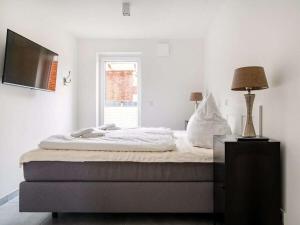 a bedroom with a bed with a lamp and a television at Holiday apartment with 2 bedrooms in Greetsiel