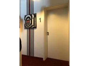 eine Tür zu einem Raum mit einem Gemälde an der Wand in der Unterkunft Comfort Apartment House Regini in Norderney
