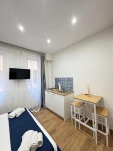 a bedroom with a bed and a kitchen with a table at Neapolitan Suites in Naples