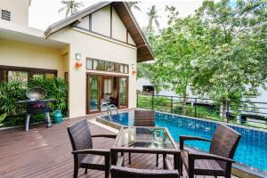 a patio with a table and chairs next to a swimming pool at Chaweng Noi Villa in Chaweng Noi Beach