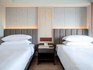 two beds sitting next to each other in a room at Hamamatsu Marriott Hotel in Hamamatsu