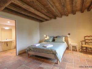 a bedroom with a bed and a table and a chair at Maison indépendante de charme avec jeux et animaux acceptés - FR-1-497-255 in Corbon