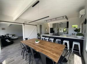 a dining room and kitchen with a wooden table and chairs at Secluded Lake Ōkāreka Studio Views, Spa, Deck in Rotorua in Rotorua