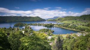 an aerial view of a lake in the hills at Secluded Lake Ōkāreka Studio Views, Spa, Deck in Rotorua in Rotorua +8 photos