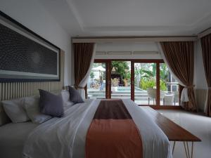 ein Schlafzimmer mit einem großen Bett und einem großen Fenster in der Unterkunft Casa Vella Cottage in Patjung + 217 Fotos