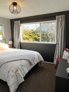 a bedroom with a bed and a large window at Boutique on Russel in Invercargill +4 photos