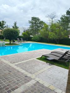 a swimming pool with two lounge chairs next to it at Hacienda Valbuena Antorcha area in León