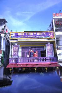 two people standing on a balcony of a building at Mộc Truly Huế - Homestay in Thôn Kim Long (1)