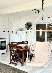 a hammock in a kitchen with a table and chairs at Casa do Aconchego Quadra 28 in Bertioga