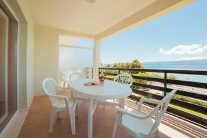a white table and chairs on a balcony with the ocean at Apartments Sea View in Omiš +54 photos