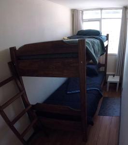 two bunk beds in a room with a window at Habitación privada con camarote en departamento compartido - Providencia in Santiago